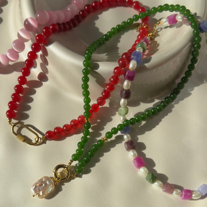 Three colorful beaded necklaces on a light background
