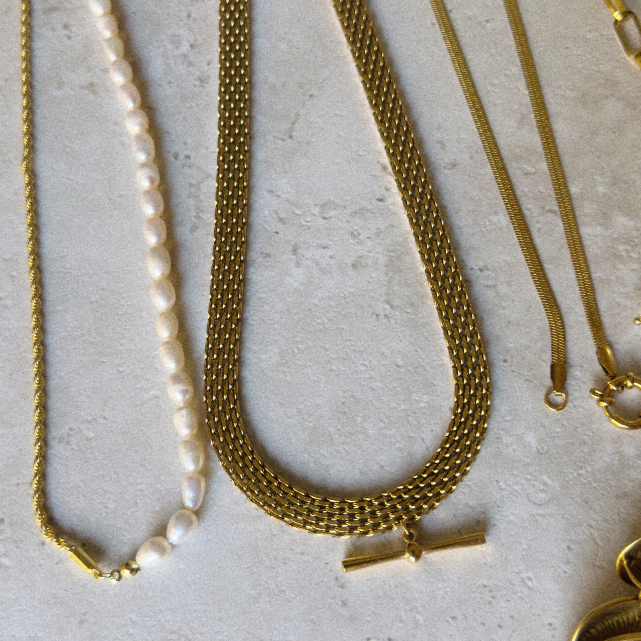 Gold necklaces on a textured surface