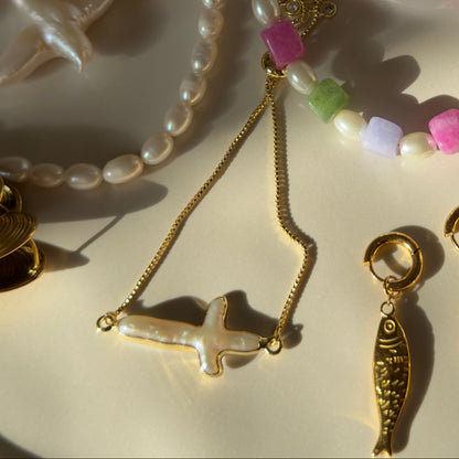 Jewelry set with necklaces, earrings, and charms on a white plate